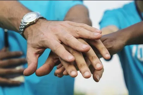 hands coming together in stack to show teamwork